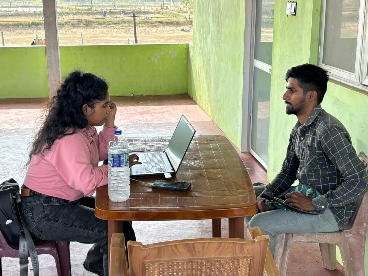 The HatchBlu team collecting farm data on a laptop with a farm partner